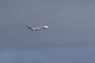 Airbus A380 jet passenger aircraft of Emirates airlines flying in a blue sky, England, United