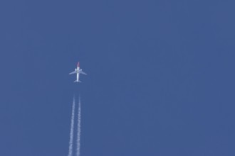 Boeing 737 jet passenger aircraft of Norweign Air with a vapour trial or contrail behind flying in
