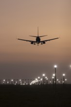 Boeing 737 jet passenger aircraft of Ryanair airlines landing over runway lights at sunset, London