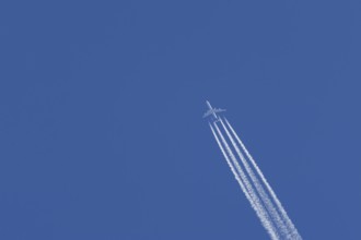 Airbus A340-300 jet aircraft of Lufthansa airlines in flight in a blue sky with vapour trails or