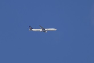 Boeing 777 jet passenger aircraft of Saudi airlines in flight in a blue sky, England, United
