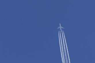 Airbus A340-300 jet aircraft of Lufthansa airlines in flight in a blue sky with vapour trails or