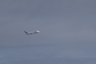 Airbus A380 jet passenger aircraft of Emirates airlines flying in a blue sky, England, United