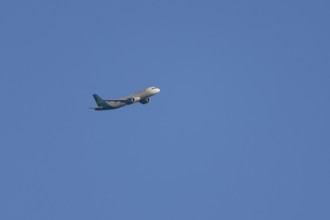 Airbus passenger jet aircraft of Aer Lingus flying in a blue sky, England, United Kingdom