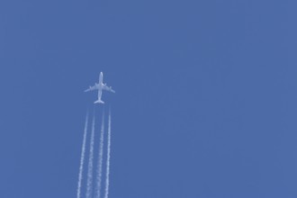 Airbus A340-300 jet aircraft of Lufthansa airlines in flight in a blue sky with vapour trails or