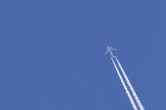 Boeing 737 jet passenger aircraft of Norweign Air with a vapour trial or contrail behind flying in