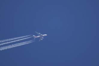 Airbus A380 jet passenger aircraft of Emirates airlines flying with vapour trails or contrails