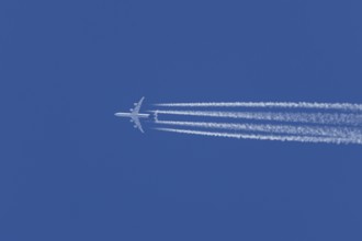 Airbus A340-300 jet aircraft of Lufthansa airlines in flight in a blue sky with vapour trails or