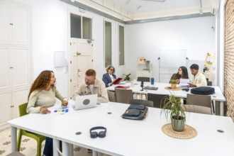 Group of diverse business professionals discussing ideas, analyzing documents, and working on