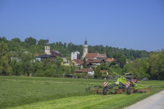 Tractor working in the field behind the village, Tittmoning, Bavaria, Germany