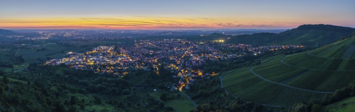 Town at sunset with illuminated streets and surrounding hills in twilight, Korb im Remstal,