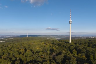 Sublime television tower above a green forest landscape with blue sky and clouds,