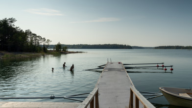 Young people swimming in the sea on a wooden jetty, Åland, Åland Islands, Finland