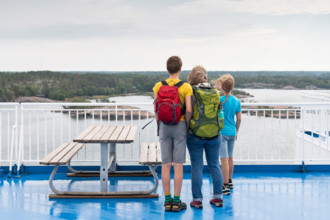 Mother with two children standing on the deck of a ferry, Åland, Åland Islands, Finland