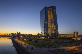 The lights of the European Central Bank (ECB) and the Frankfurt banking skyline glow in the