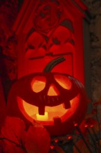 Halloween pumpkin with candlelight in the cemetery, illuminated red and spooky