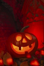 Halloween pumpkin with candlelight in the cemetery, illuminated red and spooky