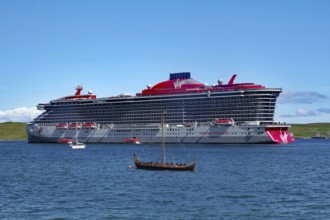 Large cruise ship next to a small Viking boat at sea, overtourism, Lerwick, Shetland Islands,