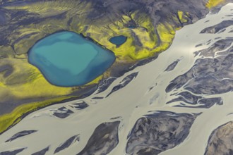 Turquoise crater lake next to intertwined glacial river, Icelandic Highlands, Iceland