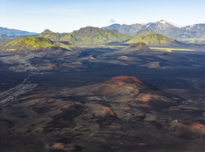 Volcanic landscape with black sand desert and red mountains, moss-covered mountains in the