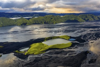 Turquoise-coloured crater lake with moss-covered crater rims in the Icelandic highlands, surrounded