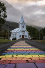 Church with rainbow pedestrian path in the town of Seyðisfjörður, East Iceland, Iceland