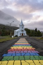 Church with rainbow pedestrian path in the town of Seyðisfjörður, East Iceland, Iceland