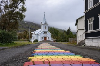 Church with rainbow pedestrian path in the town of Seyðisfjörður, East Iceland, Iceland