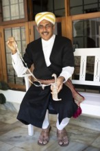 Indian man, 63 years old, from the Kodava clan in traditional dress showing a traditional dagger