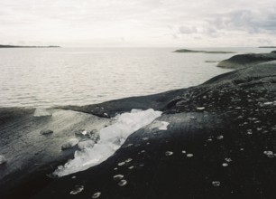 Ice remains from winter on the rocky shore of Lake Vänern, monochrome, analogue, Värmland, Sweden