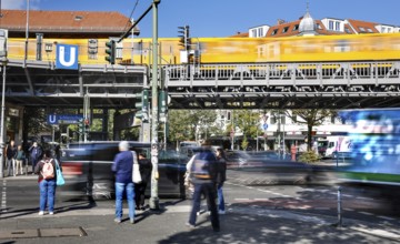 Street scene at Schlesisches Tor underground station, yellow underground train on elevated railway,