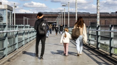 People walking across a bridge at Warschauer Straße station, Berlin, 02 October 2025, Berlin,