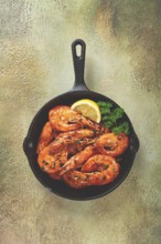 Fried white-footed shrimp, tiger shrimp baths, in a cast-iron skillet, with lemon and herbs, no