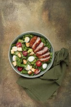 Caesar salad, with duck breast, on a green plate, homemade, no people