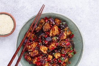 Fried eggplant, Chinese style, in sweet and sour sauce, with pepper and sesame seeds, in a green
