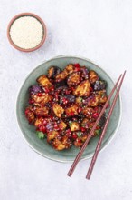 Fried eggplant, Chinese style, in sweet and sour sauce, with pepper and sesame seeds, in a green
