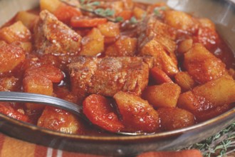 Meat goulash with potatoes and carrots, sweet peppers, in a saucepan, top view, traditional