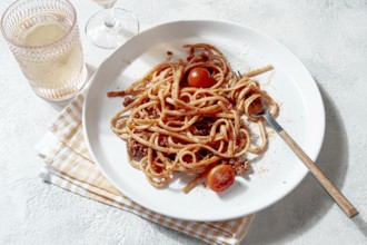 Freshly cooked spaghetti topped with savory meat sauce and garnished with cherry tomatoes is