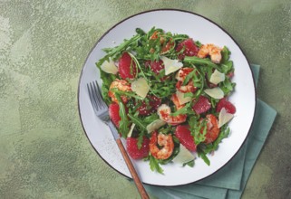 Fresh shrimp salad with arugula, grapefruit, and parmesan served in a bowl