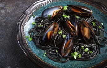 Black spaghetti, nori pasta, with mussels, top view, on a dark background, homemade, no people
