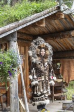Young Tlingit woman in traditional traditional costume in front of a hut, Chena Village, Alaska,