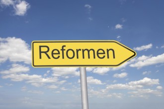 (Photomontage) Directional arrow with the inscription REFORMEN in front of a blue sky