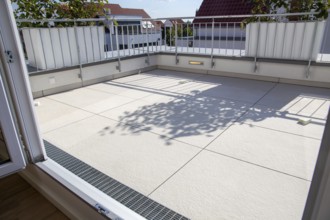 Balcony with large, light-coloured balcony tiles on a detached house