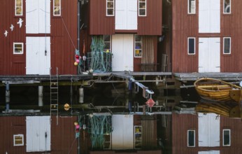 Boats and falun red boathouses in the harbour of Smögen, Smögenbryggan, Västra Götalands Län,