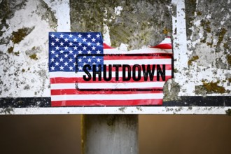 Torn sticker of US flag with shutdown printed on it, photomontage