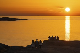 Silhouettes of tourists, sun melting in the sea, sunset, archipelago landscape, Smögen,