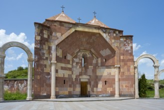 Front view of a stone church with striking arches and three crosses on the roof, Saint Trinity