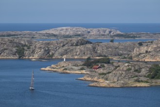 Rocky archipelago landscape with small red house by the sea, sailing ship, Fjällbacka, Bohuslän,