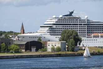 Large cruise ship MSC Poesia in the harbour, church tower in the background, Warnemünde, Rostock,