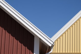 Red and yellow house gables bordering each other, blue sky, Fjällbacka, Bohuslän, West Sweden,